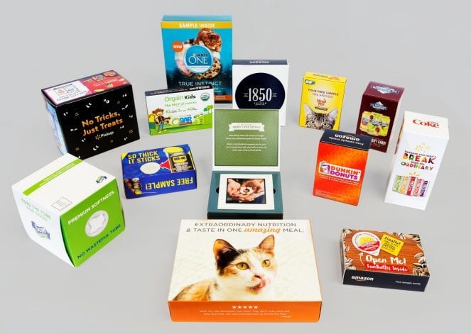 An assortment of printed retail cartons and boxes on a grey ground